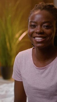 Happy smiling African American business woman looking at camera working on laptop in bedroom at night female businesswoman freelancer using computer on bed remote work from home bedtime evening indoor