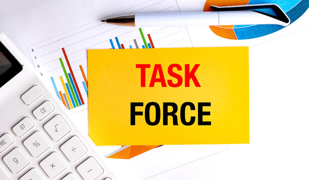 Task force text on yellow paper with calculator, pen and business charts, teamwork and management concept