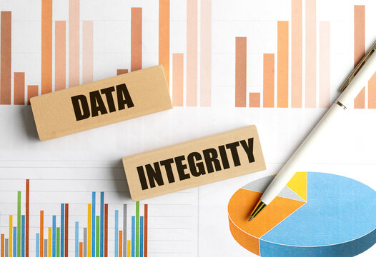 Data integrity text on wooden blocks with charts and pen, concept of information accuracy, reliability and quality