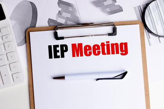 Iep meeting text on a clipboard with pen, calculator and charts, individualized education plan and student support concept