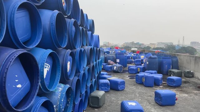 Close Up of Stacked Blue Plastic Barrels in Industrial Yard