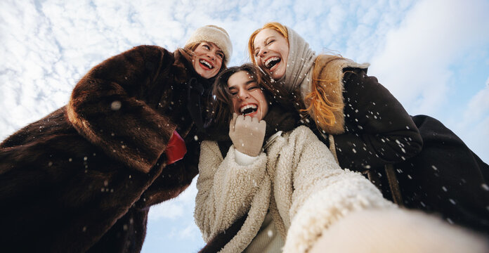 Laughing women enjoy friendship in winter sunshine