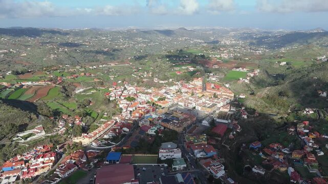 Vibrant Vega de San Mateo town on Gran Canaria. Drone pulls back and booms up over the scenic Hoya Viciosa valley.
