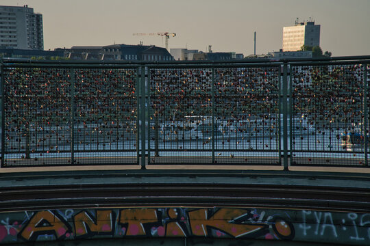 Bridge Railing with Love Locks and Graffiti in Evening Light.