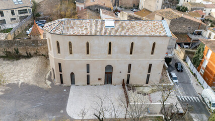 Aerial view of a renovated stone chapel with tiled roof and paved forecourt © Thomas