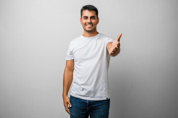 Man young t shirt smiling friendly offering handshake, business hand greeting and shake with welcoming hands - success, successful studio portrait © Krakenimages.com