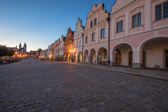 03 October 2026, Colorful Renaissance houses with arcades line the cobblestone main square after sunset in Telč, Czech Republic.