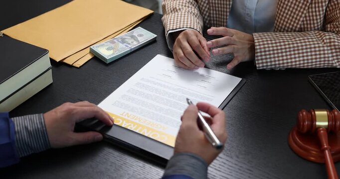 Legal consultation between a lawyer and a client, reviewing contract terms and discussing legal options to resolve disputes, protect rights, and make informed decisions.