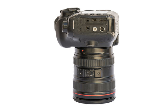 Detailed shot of professional DSLR camera body connected to lens on plain white background. Camera's side panel showcases ports, while lens features zoom rings and a red indicator light.