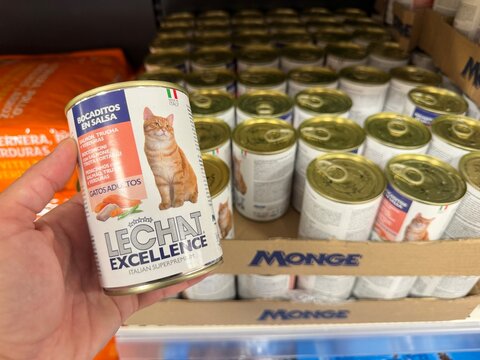 Mallorca, spain, october 07, 2026 hand holding le chat excellence cat food can in a supermarket aisle, choosing pet supplies for feline nutrition