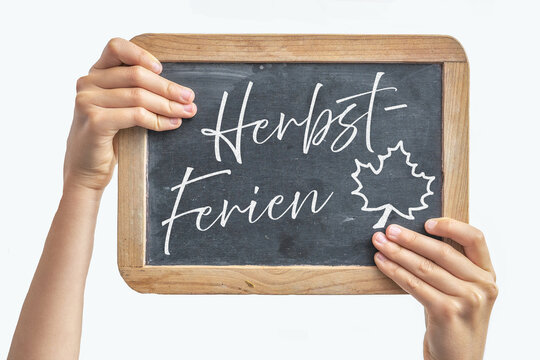 Schule Ausbildung Ferien - Kind h&auml;lt Schultafel mit Text "Herbstferien", isoliert auf weissem Hintergrund
