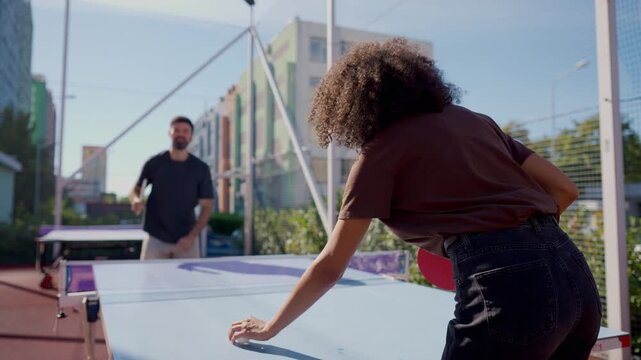 Friends playing outdoor table tennis together