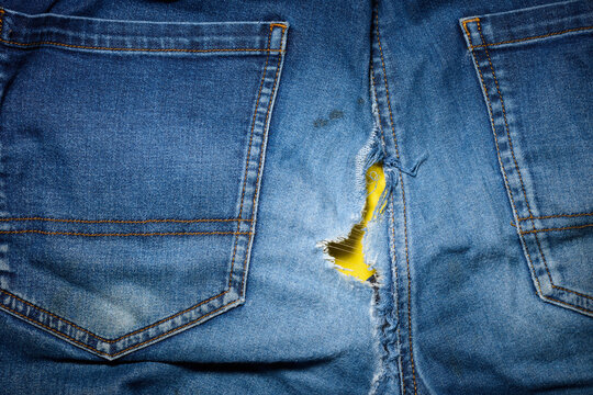 Close-up of a pair of old, worn-out blue jeans on a table.