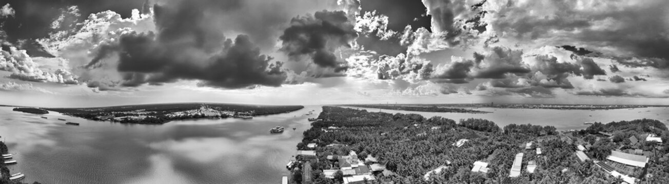 Top down aerial panoramic view of Mekong Delta lush green rice fields and river tributaries