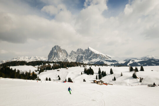 snow covered ski resort in winter time in italian dolomites with man on skis