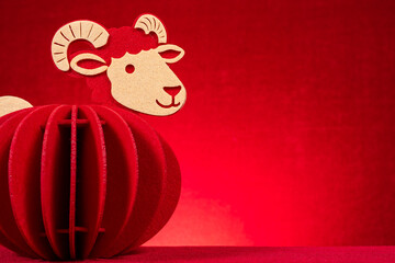 Red layered felt sheep lantern ornament for Chinese New Year on red background © Freer