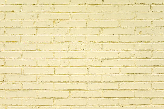 Pale yellow painted brick wall with clear brick and mortar texture