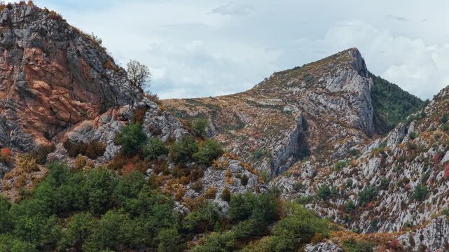 Aerial view of premature foliage yellowing and colorful dry mountain slopes due to severe heatwave near Ainsa, Pyrenees, Spain