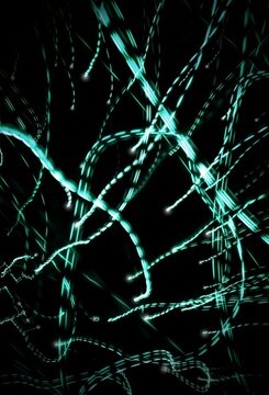 Abstract light trails on a black background with a motion blur effect. Neutral graphic background.