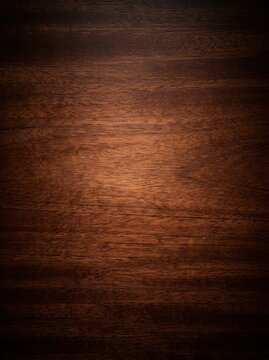 Dark Brown Wood Texture Background with Central Spotlight and Elegant Grain Pattern for Professional Design Projects