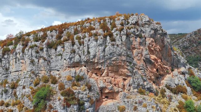 Aerial view of premature foliage yellowing and colorful dry mountain slopes due to severe heatwave near Ainsa, Pyrenees, Spain