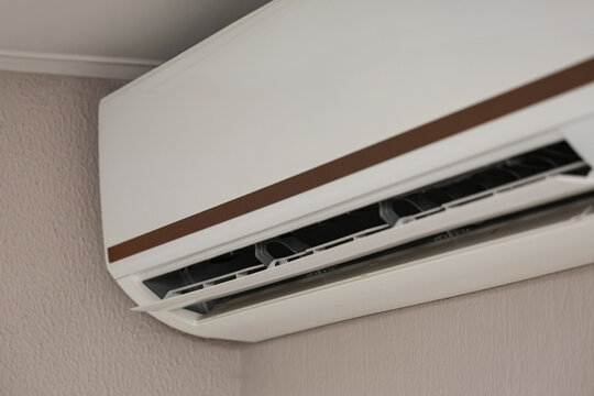 Air conditioning and climate control, modern wall mounted split system unit for home cooling and heating efficiency in a residential interior room