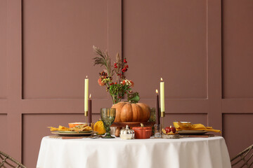 Fototapeta premium Thanksgiving dinner table setting, autumn harvest celebration and holiday hospitality with pumpkin centerpiece and candles in a cozy dining room