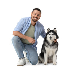 Pet ownership and companionship, happy man kneeling with his husky dog for animal care and friendship concept isolated on a clean white background © Pixel-Shot