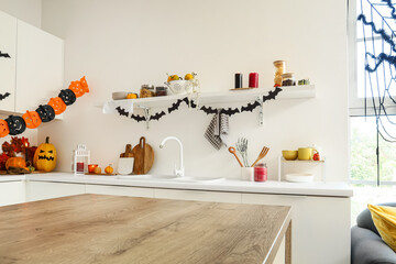 Fototapeta premium Halloween home decor, festive kitchen interior with pumpkins and bat garlands for autumn holiday celebration and seasonal party preparation