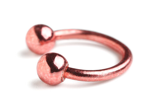 Body piercing and fashion accessories, rose gold circular barbell jewelry for ear or septum piercing isolated on a clean white background