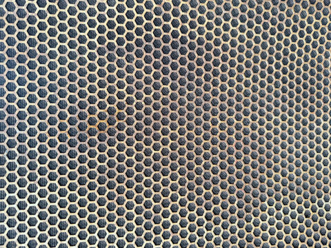 black speaker grill mesh with golden honeycomb pattern, abstract audio equipment background