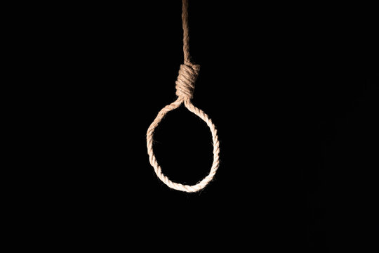 Suicide prevention and mental health crisis rope noose hanging in darkness as a metaphor for depression despair and end of life struggle
