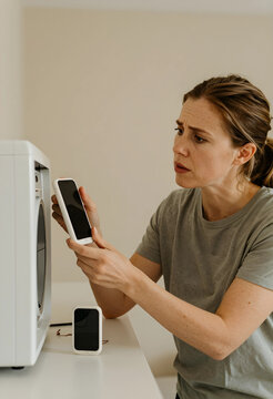 Tech support and troubleshooting, frustrated woman trying to connect smartphone to smart home device with confusion and technical difficulty at home