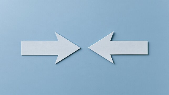 Two white arrows pointing in opposite directions on a light blue background. the arrows are made of paper and are positioned in a way that they are pointing towards the right side of the image.