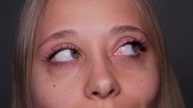 Young woman touches her lashes and demonstrates the result of eyelash extensions or false eyelashes in a soft close-up beauty portrait