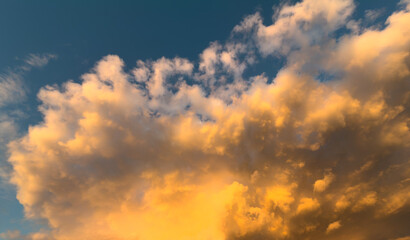 Golden clouds drift against a deep blue sky © schankz
