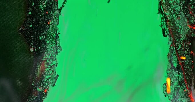 Burning Fabric Chars Against Green Screen. Thin fabric burns and chars against green screen with ember bright edges and brittle black residue. 