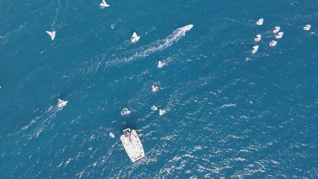 Top Down Aerial View of Optimist Sailing Dinghies Moving in a Group Across Deep Blue Mediterranean Sea Near Kalamata, Greece