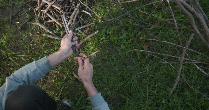 Close-up male hands break twigs, chop branches for firewood. 4K 10-b
