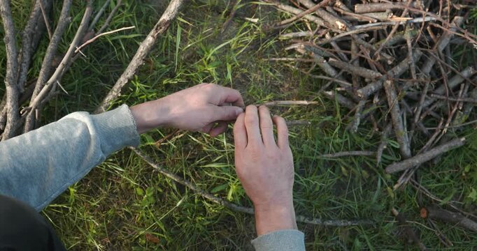 Close-up male hands break twigs, chop branches for firewood. 4K 10-b