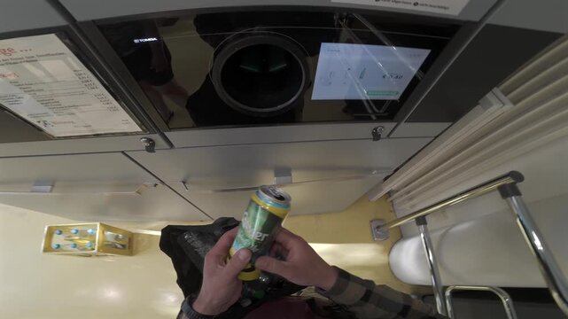 POV first person view of a man returning empty plastic bottles into a reverse vending machine inside a German supermarket for recycling and receiving a deposit refund