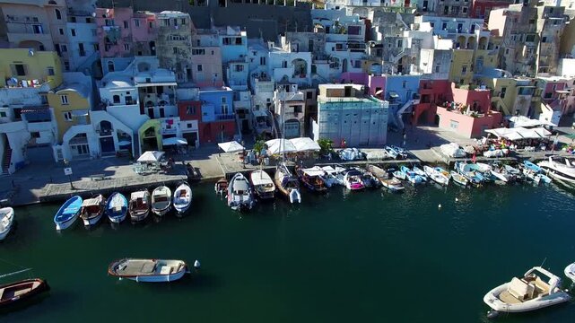 Fishing boats beside colorful waterfront buildings on Procida Italy
