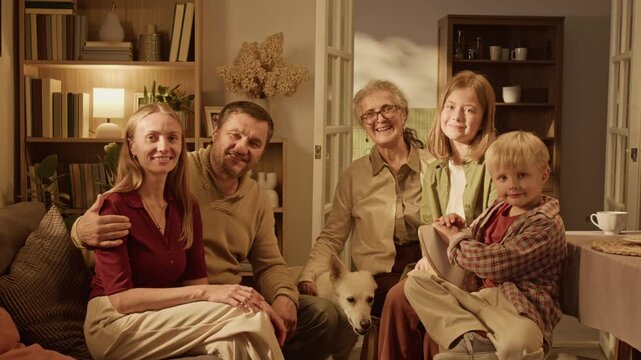 Portrait of multigenerational Caucasian family with senior woman, middle aged parents, teenager, child and dog smiling at camera. Footage suitable for health insurance campaigns