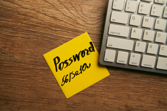 password text on yellow sticky note on keyboard.