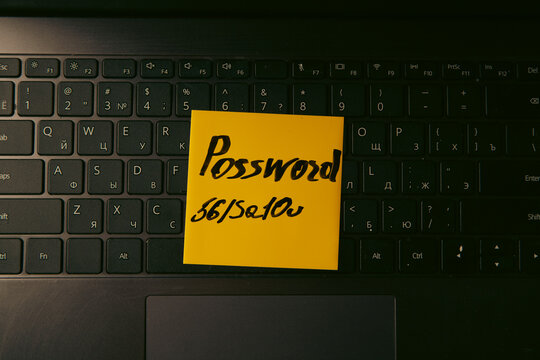 password text on yellow sticky note on keyboard.