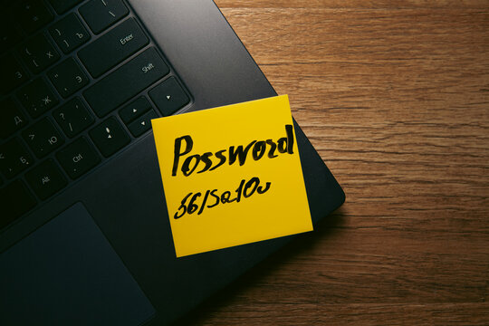 password text on yellow sticky note on keyboard.