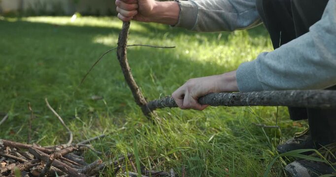 Close-up male hands break twigs, chop branches for firewood. 4K 10-b