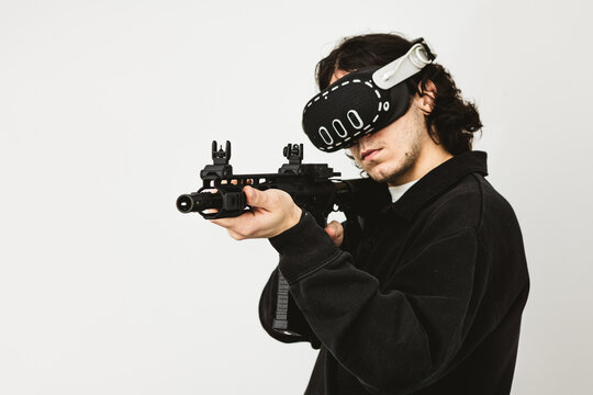 Man wearing virtual reality headset aiming AR-15 rifle controller in VR training simulation