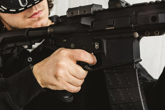 Man wearing virtual reality headset aiming AR-15 rifle controller in VR training simulation
