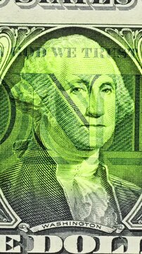 Moving green light sweeps across George Washington bill, causing banknote glow. 